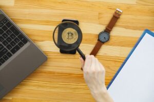 A laptop displaying a bitcoin wallet on a wooden table, highlighting common mistakes in cryptocurrency management